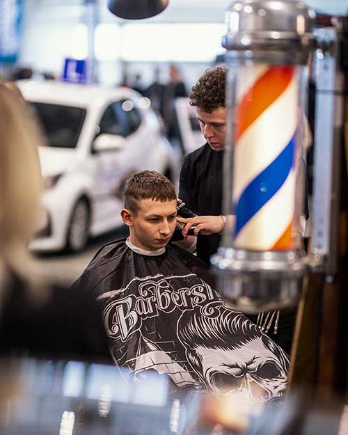 Strzyżenie przy klasycznej lampie barberskiej – styl i detal na pierwszym planie.