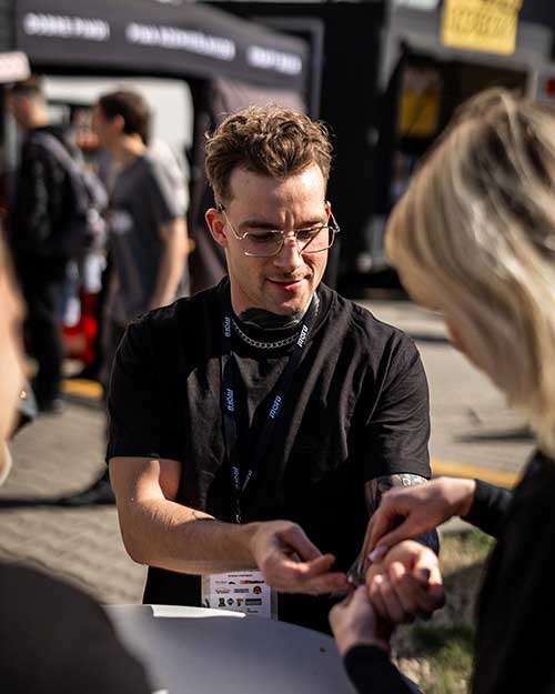 Roksana pomaga Matiemu zapiąć targową opaskę. Zaraz powrót za fotel na naszym stanowisku!