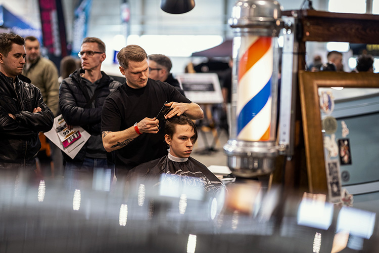 Klasyczne cięcie na tle barberpola – skupienie i ruch w całej hali.