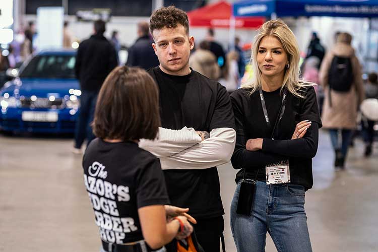 ekipa podczas rozmowy – czarne koszulki, identyfikatory, energia na poziomie.