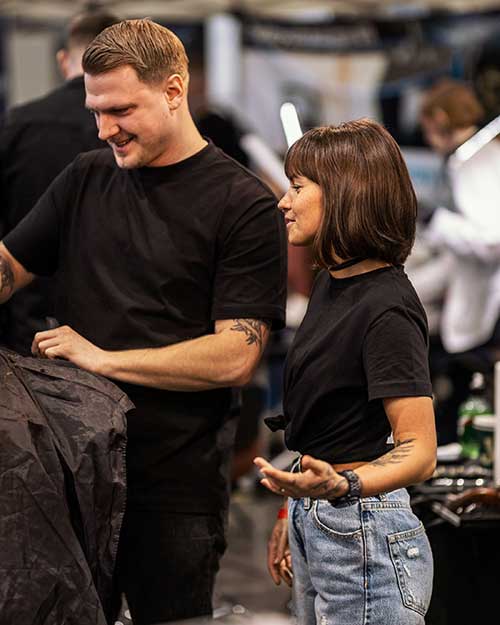 Rozmowa przy stanowisku – Kuba i Kasia w luźnej, roboczej pogawędce.